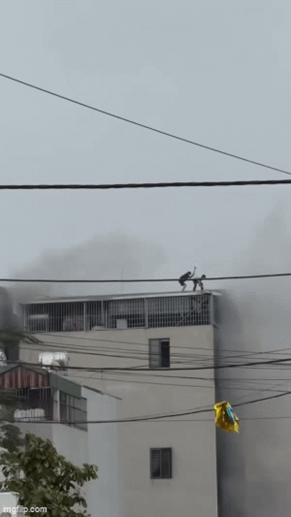 2 người phá mái tôn cứu các nạn nhân từ căn nhà 6 tầng cháy dữ dội ở Hà Nội